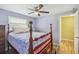Bedroom features wood-look floors, a ceiling fan, and a large window at 6246 Bandura Ave, New Port Richey, FL 34653