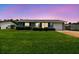 Well-maintained single-story home with a green lawn and beautiful twilight sky at 6246 Bandura Ave, New Port Richey, FL 34653