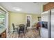 Eat-in kitchen area showcases modern wood-look flooring and stainless steel refrigerator at 6246 Bandura Ave, New Port Richey, FL 34653