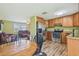 Open kitchen with stainless appliances, wooden cabinets, and adjacent living area at 6246 Bandura Ave, New Port Richey, FL 34653