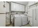 Functional laundry area with white washer, dryer, and ample cabinet space for storage at 6246 Bandura Ave, New Port Richey, FL 34653