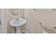 Compact half-bathroom featuring a pedestal sink, oval mirror, and grab bar for added accessibility at 6912 40Th N Ln, Pinellas Park, FL 33781