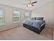 Neutral bedroom with ceiling fan, two windows with blinds, and a large bed with storage at 6912 40Th N Ln, Pinellas Park, FL 33781