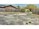 View of a concrete backyard patio enclosed by a wood fence, with a home in the background at 7012 Pin Cherry Ln, Port Richey, FL 34668