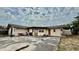 Expansive backyard featuring concrete patio, table and chairs, and exterior doors at 7012 Pin Cherry Ln, Port Richey, FL 34668