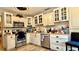 Bright kitchen featuring stainless steel appliances, ample cabinet space, and wood-look flooring at 7012 Pin Cherry Ln, Port Richey, FL 34668
