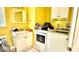 Bright laundry room features washer, dryer, sink, and cabinets for ample storage at 7012 Pin Cherry Ln, Port Richey, FL 34668