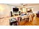 Open-concept living room with wood floors, tv, large sofa, and ceiling fan at 7012 Pin Cherry Ln, Port Richey, FL 34668