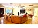 Spacious living room featuring hardwood floors, a large sofa, and modern entertainment center at 7012 Pin Cherry Ln, Port Richey, FL 34668