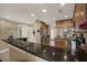Kitchen with stainless steel fridge, dark granite counters, and wooden cabinets, offering ample space at 7069 Key Haven Rd # 602, Seminole, FL 33777