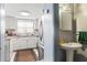 Bathroom sink with a white pedestal and stainless faucet, next to the kitchen at 7606 Woodbridge Blvd, Tampa, FL 33615