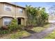 Charming townhouse showcasing a covered entryway and beautiful mature palm trees at 7606 Woodbridge Blvd, Tampa, FL 33615