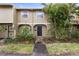 Charming townhouse with lush landscaping and a welcoming covered front entryway at 7606 Woodbridge Blvd, Tampa, FL 33615