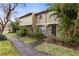 Inviting townhouse featuring lush landscaping and a charming covered entryway at 7606 Woodbridge Blvd, Tampa, FL 33615
