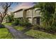 Inviting townhouse featuring lush landscaping and a charming covered entryway at 7606 Woodbridge Blvd, Tampa, FL 33615