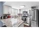 Beautiful kitchen with granite countertops, stainless appliances, white cabinetry, and tile flooring at 7606 Woodbridge Blvd, Tampa, FL 33615