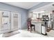 Bright kitchen featuring white cabinets, stainless appliances, granite counters, and a door leading to the outside at 7606 Woodbridge Blvd, Tampa, FL 33615