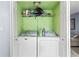 Convenient laundry closet equipped with a washer and dryer and storage shelf at 7606 Woodbridge Blvd, Tampa, FL 33615