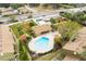 Aerial view of complex showing a uniquely shaped pool with seating areas and landscaping around the condominium units at 7606 Woodbridge Blvd, Tampa, FL 33615