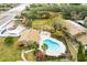 Aerial view of complex featuring a uniquely shaped pool surrounded by lush landscaping and multiple seating areas at 7606 Woodbridge Blvd, Tampa, FL 33615