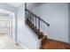 Elegant staircase featuring wooden steps, sleek black railing, and neutral wall paint at 7606 Woodbridge Blvd, Tampa, FL 33615
