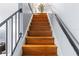 Interior staircase with wooden steps and metal handrail, offering seamless transition between floors at 7606 Woodbridge Blvd, Tampa, FL 33615