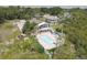Aerial view of a property with a pool, patio, and a two-story house surrounded by lush greenery at 8117 Bay Dr, Tampa, FL 33635