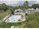 Aerial view of a two-story house with a pool, deck, and lush green surroundings at 8117 Bay Dr, Tampa, FL 33635
