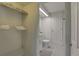 Small, brightly lit bathroom with a toilet, sink, and shelving unit at 8117 Bay Dr, Tampa, FL 33635