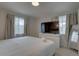 Light bedroom with large TV on dresser and ample natural light from the windows at 8117 Bay Dr, Tampa, FL 33635
