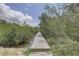 A wooden dock surrounded by lush greenery and water, leading towards a serene waterfront at 8117 Bay Dr, Tampa, FL 33635