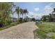 Property featuring a brick driveway leading up to a two-story home surrounded by palm trees at 8117 Bay Dr, Tampa, FL 33635
