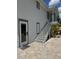 Beautiful white two-story home featuring a gray staircase and elegant glass railings on the side at 8117 Bay Dr, Tampa, FL 33635
