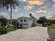 Beautiful exterior of a two-story home with a brick driveway and lush tropical landscaping at 8117 Bay Dr, Tampa, FL 33635