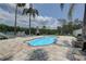Inviting backyard pool featuring an outdoor fireplace, lounge chairs, and a surrounding deck at 8117 Bay Dr, Tampa, FL 33635