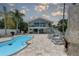 Backyard pool with lounge chairs, outdoor fireplace, and a two-story house with balconies at 8117 Bay Dr, Tampa, FL 33635