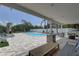 Covered outdoor patio featuring comfortable seating, a barbecue, and a lovely pool with outdoor fireplace at 8117 Bay Dr, Tampa, FL 33635
