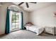 Cozy bedroom with a large arched window, blue drapes, and plush carpeting at 8913 Welsh Way, Hudson, FL 34667