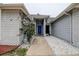 Charming front entrance featuring a blue door, brick accents, and beautiful landscaping at 8913 Welsh Way, Hudson, FL 34667
