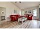 Bright living room featuring a vaulted ceiling and neutral paint with red sofas at 8913 Welsh Way, Hudson, FL 34667
