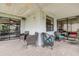 Relaxing covered patio with brick flooring and comfortable wicker seating arrangement at 8913 Welsh Way, Hudson, FL 34667
