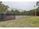 Fenced tennis court on a lush green lawn, providing a private recreational space for residents at 8913 Welsh Way, Hudson, FL 34667