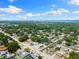 Scenic aerial view of the property highlighting its location within a lush, tree-lined neighborhood with clear blue skies at 895 Joan St, Dunedin, FL 34698