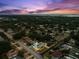 Breathtaking aerial view of a residential area with a home featuring a private pool and lush landscaping at 895 Joan St, Dunedin, FL 34698