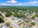 Wide aerial view showing the property with pool and lush surroundings in the neighborhood at 895 Joan St, Dunedin, FL 34698