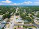 Wide aerial view showing the property with pool and lush surroundings in the neighborhood at 895 Joan St, Dunedin, FL 34698