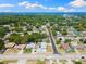 Expansive aerial view of property showcasing the home, pool, manicured lawn, and surrounding neighborhood near the waterfront at 895 Joan St, Dunedin, FL 34698