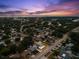 Expansive aerial shot of the property in its neighborhood with pool, patio, and landscaping at 895 Joan St, Dunedin, FL 34698