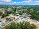 Property aerial view emphasizing neighborhood, mature trees, and street layout, featuring a pool and well-maintained surroundings at 895 Joan St, Dunedin, FL 34698