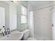 Bright bathroom featuring a shower with white tile, a window, and updated fixtures at 895 Joan St, Dunedin, FL 34698